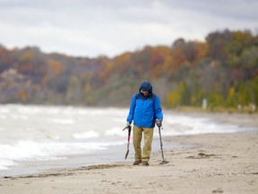 A bundled-up Peter Worozbyt of Vineland Ontario takes some time to do metal detecting on the main beach in Port Stanley, south of London, Ont. Worozbyt is in the area visting family and said he hadn't found much so far in the day's hunt. Photograph taken on Monday October 29, 2018.  Mike Hensen/The London Free Press/Postmedia Network