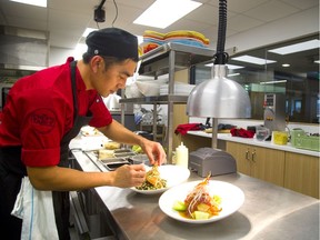 Fanshawed College student Mark Besanes dresses a plate to be served at the Chefs Table in the college’s new Dundas Street complex in London Monday. (MIKE HENSEN, The London Free Press)