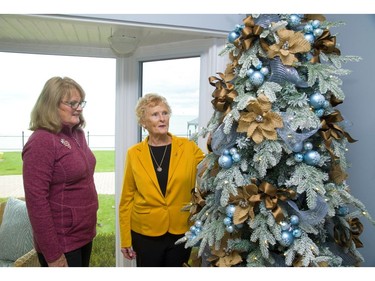 Homeowner June Ayrhart and holiday home tour organizer Patricia Martyn admire the  tree decorated in sand and surf colours to match the blue decor that dominates at 204 Adelaide St., Port Stanley. Mike Hensen/The London Free Press