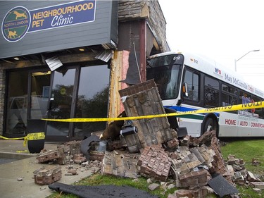 A London Transit bus sits smashed against the Neighbourhood Pet Clinic on Oxford Street between Waterloo and Colborne street in London on the morning of Oct. 31, 2018 after a late-night collision. (Derek Ruttan/The London Free Press)