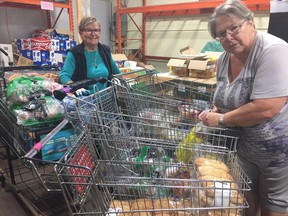 London Food Bank volunteers Kate Ditor, left, and Nicole McClean sort donated food items on Wednesday. (HEATHER RIVERS/The London Free Press)