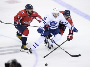 Leafs’ Par Lindholm tries to hold off both Alex Ovechkin (left) and Matt Niskanen of the Caps on Saturday in D.C.  NICK WASS/AP