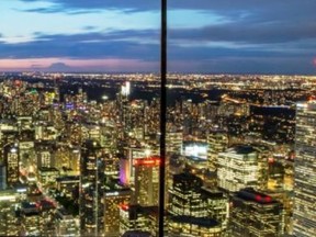 New floor-to-ceiling windows on the observation deck make this night-time panoramic view of Toronto from atop the CN Tower nearly seamless.