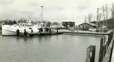 An empty boat dock at right would normally contain the fishtug Captain K. A fishtug GlenDave of Port Dover sits at its berth to the left, 1991. (London Free Press files)