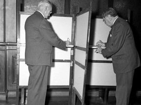 When London voters went to the polls in December 1948, they had new double booths instead of the old single style. Here, Alderman E.A. Bettam, chair of the city finance committee (left) and Mayor George Wenige cast mock votes at the new booth as a demonstration. (Photo courtesy of The London Free Press Collection of Photographic Negatives, Western Archives, Western University)