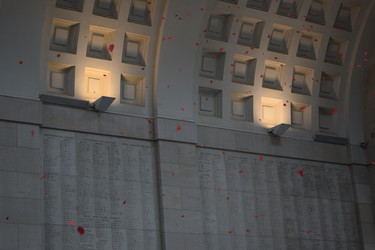 Red crepe paper poppy petals float from the top of the Menin Gate at the centennial commemoration of the armistice that ended the First World War. (Jennifer Bieman/The London Free Press)