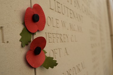 Two paper poppies mark names of soldier with no known graves on the wall of the Menin Gate in Ypres, Belgium. (Jennifer Bieman/The London Free Press)