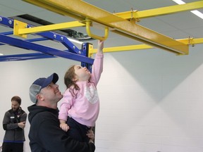 BJ Gallivan helps his three-year-old daughter, Sydney, go through one of the obstacles at a “ninja warrior” course for kids at the new YMCA at the Bostwick Community Centre in London. JONATHAN JUHA/THE LONDON FREE PRESS