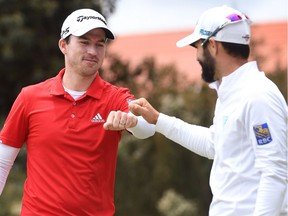 Nick Taylor, left, and Adam Hadwin of Canada bump fists on the final day of the World Cup of Golf at the Metropolitan Golf Club in Melbourne on November 25, 2018.