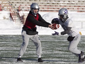 Western quarterback Chris Merchant gives a handoff during practice Friday on the eve of the Vanier Cup against the Laval Rouge et Or in Quebec City.