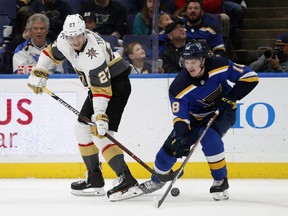Vegas Golden Knights' Shea Theodore (27) passes around St. Louis Blues' Robert Thomas during the second period of an NHL hockey game Thursday, Nov. 1, 2018, in St. Louis. (AP Photo/Jeff Roberson)