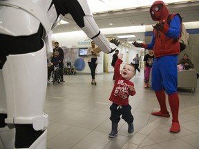 Eighteen-month-old Carter Reid of London bypasses Spider-Man to high-five an Imperial Stormtrooper at the Children's Hospital. (Derek Ruttan/The London Free Press)