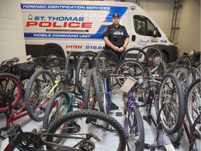 St. Thomas Const. Dan Gillies is surrounded Friday by some of the stolen bicycles recently recovered by police in St. Thomas. (Derek Ruttan/The London Free Press)