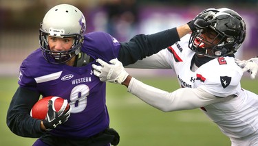 Western slotback Francois Rocheleau gets a straight arm on Carleton's Jon Edouard early in their semi-final Saturday November 3, 2018 at Td stadium.
Western won 39-13 and will move on to face Guelph next week at home for the Yates Cup.
Mike Hensen/The London Free Press/Postmedia Network