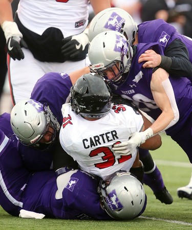 Western defensive lineman and linebackers gang up to stop Raven's running back Nathan Carter during their semi-final Saturday November 3, 2018 at Td stadium.
Western won 39-13 and will move on to face Guelph next week at home for the Yates Cup.
Mike Hensen/The London Free Press/Postmedia Network