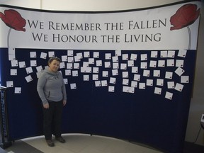 The Royal Canadian Regiment Museum's Executive Director  Georgiana Stanciu  stands in front of the "living wall" at the museum in London. Visitors are encouraged to leave notes on the wall. (Derek Ruttan/The London Free Press)