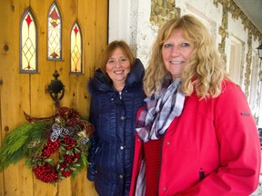 Beth Moyer and Patti Leschied are the founders of the Christmas Home Tour sponsored by Kilworth United Church. They are at the front door of the stone cottage home of Andrew Mitchell near Kilworth decorated by Parkway Gardens.  (Mike Hensen/The London Free Press)