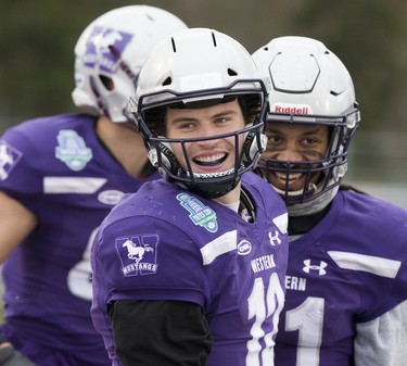 Western Mustangs Chris Merchant (foreground) and Cedric Joseph flash championship smiles after one of Merchant's touchdowns against the Guelph Gryphons during the Yates Cup OUA championship game at TD Stadium in London, Ont. on Saturday November 10, 2018. Western won the game 63-14. Derek Ruttan/The London Free Press/Postmedia Network