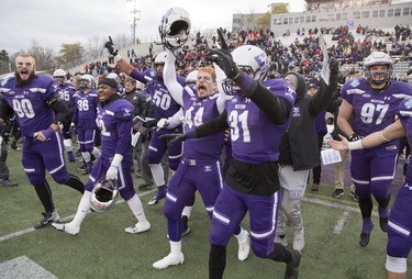 The Western Mustangs celebrate with the Yates Cup following the team's 63-14 win over the Guelph Gryphons in the Ontario University Athletics championship game at TD Stadium in London on Saturday Nov. 10, 2018. Derek Ruttan/The London Free Press