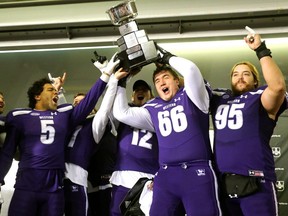 David Brown of the Western Mustangs holds up the Mitchell Bowl after the Mustangs rang up a convincing 47-24 win against the Saskatchewan Huskies Saturday, punching their tickets for Quebec City next week against Laval in the Vanier Cup. (Mike Hensen/The London Free Press)