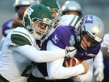 After getting beat up early by the Saskatchewan Huskies, Western quarterback Chris Merchant called his own number on a sneak to keep a drive alive in the first quarter. Merchant is tackled by Bowan Lewis of the Huskies.
The Mustangs fought to a 17-17 tie at the half with a Mark Liegghio field goal before taking control in the second half for a convincing 47-24 win punching their tickets for Quebec City next week against Laval in the Vanier Cup. 
Photograph taken on Saturday November 17, 2018.