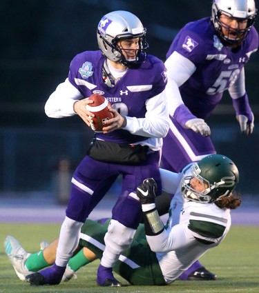 After getting beat up early by the Saskatchewan Huskies, Western quarterback Chris Merchant is nearly sacked by Saskachewan linebacker Ben Whiting before throwing the ball away.
The Mustangs fought to a 17-17 tie at the half with a Mark Liegghio field goal before taking control in the second half for a convincing 47-24 win punching their tickets for Quebec City next week against Laval in the Vanier Cup. 
Photograph taken on Saturday November 17, 2018.