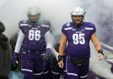 David Brown, and Jimmy Hawley of the  Western Mustangs emerge from the smoke Saturday at TD stadium to play the Mitchell Bowl against the Saskatchewan Huskies.
The Mustangs fought to a 17-17 tie at the half with a Mark Liegghio field goal before taking control in the second half for a convincing 47-24 win punching their tickets for Quebec City next week against Laval in the Vanier Cup. 
Photograph taken on Saturday November 17, 2018. 
Mike Hensen/The London Free Press/Postmedia Network