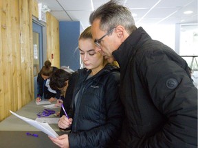 Wayne Reeves helps his 16-year-old daughter Mia fill out a questionnaire for the Boler Mountain job fair on Sunday Nov. 18, 2018. Mia Reeves is trying to land her first job and wants to work at the rental shop, so she can learn customer service. Her dad says they ski at Boler so often she might as well work there. (Mike Hensen/The London Free Press)