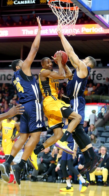 Marcus Capers of the Lightning gets squeezed under the hoop by Keith Wright Jr. and Guillaume Boucard of the St. John's Edge during the Lightning's season opener at Budweiser Gardens on Sunday Nov. 18, 2018. (Mike Hensen/The London Free Press)