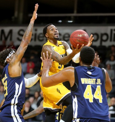 Kevin Ware Jr. of the Lightning goes up for a layup between Todd Brown Jr. and Keith Wright Jr. St. John's Edge during the Lightning's season opener at Budweiser Gardens on Sunday Nov. 18, 2018. (Mike Hensen/The London Free Press)