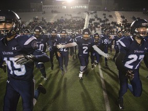 Lucas Vikings storm the field after defeating CCH 28-3 to win the junior football championship at TD Stadium in London. Derek Ruttan/The London Free Press/Postmedia Network