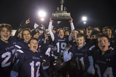 Lucas Vikings quarterback Mack Baker hoists the junior football championship trophy after defeating CCH 28-3 at TD Stadium in London. Derek Ruttan/The London Free Press/Postmedia Network