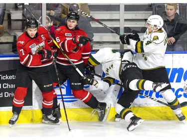 William Lochead inadvertently body checks fellow London Knight Billy Moskal after his target Kaleb Pearson slipped out the way during the first period of their OHL game at Budweiser Gardens on Friday night. Beside Pearson is Owen Sound Attack captain and London native Nick Suzuki. (Derek Ruttan/The London Free Press)