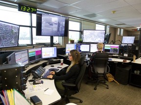 911 emergency dispatchers sit surrounded by screens in the London Police communication office. Mike Hensen/The London Free Press/Postmedia Network