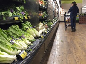 Romaine Lettuce still sits on the shelves as a shopper walks through the produce area. (Mark J. Terrill/THE CANADIAN PRESS/AP)