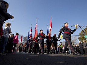 A colour guard leads a parade of veterans and current military personnel as they march along Dufferin Avenue following the Remembrance Day ceremony at the Cenotaph in Victoria Park in London on November 11, 2015.  (Free Press file photo)