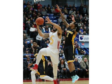 Grandy Glaze, of the Sudbury Five, goes up for a shot as  Xavier Moon, of the London Lightning, attempts to block the shot during basketball action at the Sudbury community arena in Sudbury on Thursday Nov. 22. John Lappa/Postmedia Network