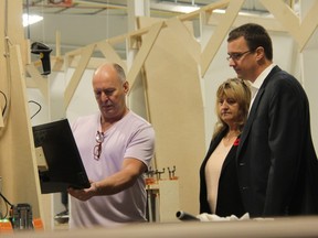 Woody’s Custom Cabinetry co-owner Dan Fentie, left, shows Strathroy-Caradoc Mayor Joanne Vanderheyden and Infrastructure Minister Monte McNaughton some of the technology used at the Strathroy business, which specializes in high-end cabinetry for luxury homes. McNaughton, the Lambton-Kent-Middlesex MPP, was at the Strathroy business Friday promoting the provincial government’s Making Ontario Open for Business Act. (JONATHAN JUHA/THE LONDON FREE PRESS)