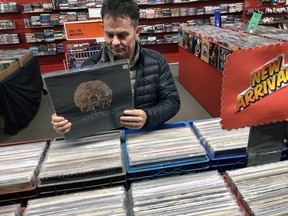 Doug Marsh, owner of The Record Works in Woodstock, looks over some used records that will be on sale as part of the Black Friday celebration. (BRUCE URQUHART/Postmedia News)