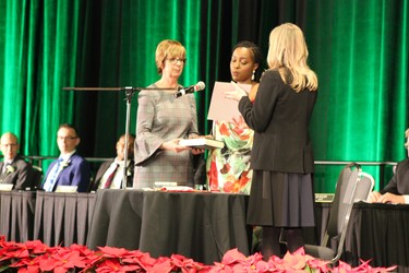 Arielle Kayabaga, Ward 13 councillor, is sworn in by city clerk Cathy Saunders (left) and deputy city clerk Barb Westlake-Power (right) on Dec. 3, 2018, as other city councillors look on from the stage at the London Convention Centre. (MEGAN STACEY/The London Free Press)