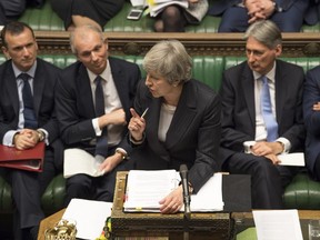 Britain's Prime Minister Theresa May, centre, gives a reply to lawmakers during the scheduled Prime Minister's Questions time, in the House of Commons, London, Wednesday Dec. 5, 2018. Britains House of Commons opened round two Wednesday in a bruising battle between lawmakers and Prime Minister Theresa May's government over Britain's Brexit split with the EU. (UK Parliament, Mark Duffy via AP)