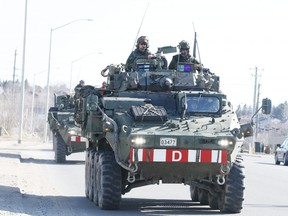 Canadian soldiers drive a convoy of 37 light armoured vehicles — made at General Dynamics Land Systems Canada in London — through Sudbury in the spring during a driving exercise in preparation for their deployment  to Latvia. A deal to make similar vehicles for Saudi Arabia has come under scrutiny because of the desert kingdom’s poor human rights record. Readers weigh in on whether the deal should be kept. (Postmedia file photo)