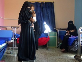 A Yemeni mother holds her malnourished child as they wait for treatments in a medical centre in the village of Al Mutaynah, in the Tuhayta province, western Yemen, on November 29, 2018.