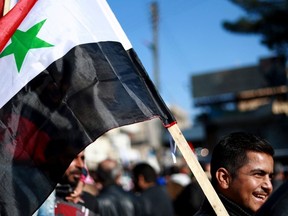 Syrian demonstrators wave the national flag during a demonstration in the northeastern Syrian Kurdish-majority city of Qamishli on December 23, 2018, asking for the Syrian army's protection as Turkey threatens to carry out a fresh offensive  following the US decision to withdraw their troops. (Photo by Delil SOULEIMAN / AFP)DELIL SOULEIMAN/AFP/Getty Images