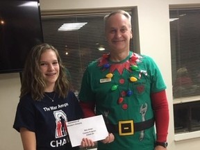Child amputee Hayley Gardiner accepts a donation to the War Amps Child Amputee program from the president of the Corvettes of Western Ontario Club, Lino Prelazzi. (Submitted photo)