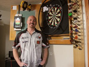 Londoner Jim Long stands next to his dart board at his London home on Monday. Last month, Long participated in the world dart championship in England for the first time, defeating in the first round the 66th seed of the tournament. (JONATHAN JUHA, The London Free Press)