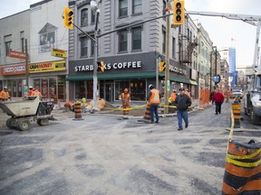 Pedestrians take to the freshly paved intersection as workers build sidewalks at Richmond Street and Dundas Street. (File photo)