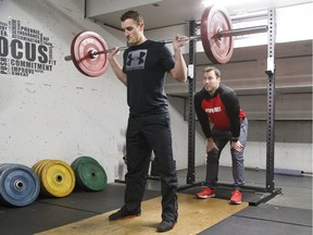 Curtis Thorner performs squats under the guidance of Olympic bobsledder and trainer Josh Kirkpatrick at Total Package Hockey on Wednesday.  (DEREK RUTTAN, The London Free Press)