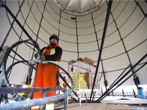 Tyler Lyons, of Greatario, an Innerkip-based company, uses hydraulic jacks to lift a new water tower being built in Delaware west of London. (MIKE HENSEN, The London Free Press)