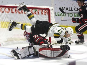 Even with Paul Cotter of the London Knights flying over him, Niagara IceDogs goalie Stephen Dhillon was able to reach back and grab the puck before it rolled over the goal line in first-period action at Budweiser Gardens in London Friday.
Derek Ruttan/The London Free Press